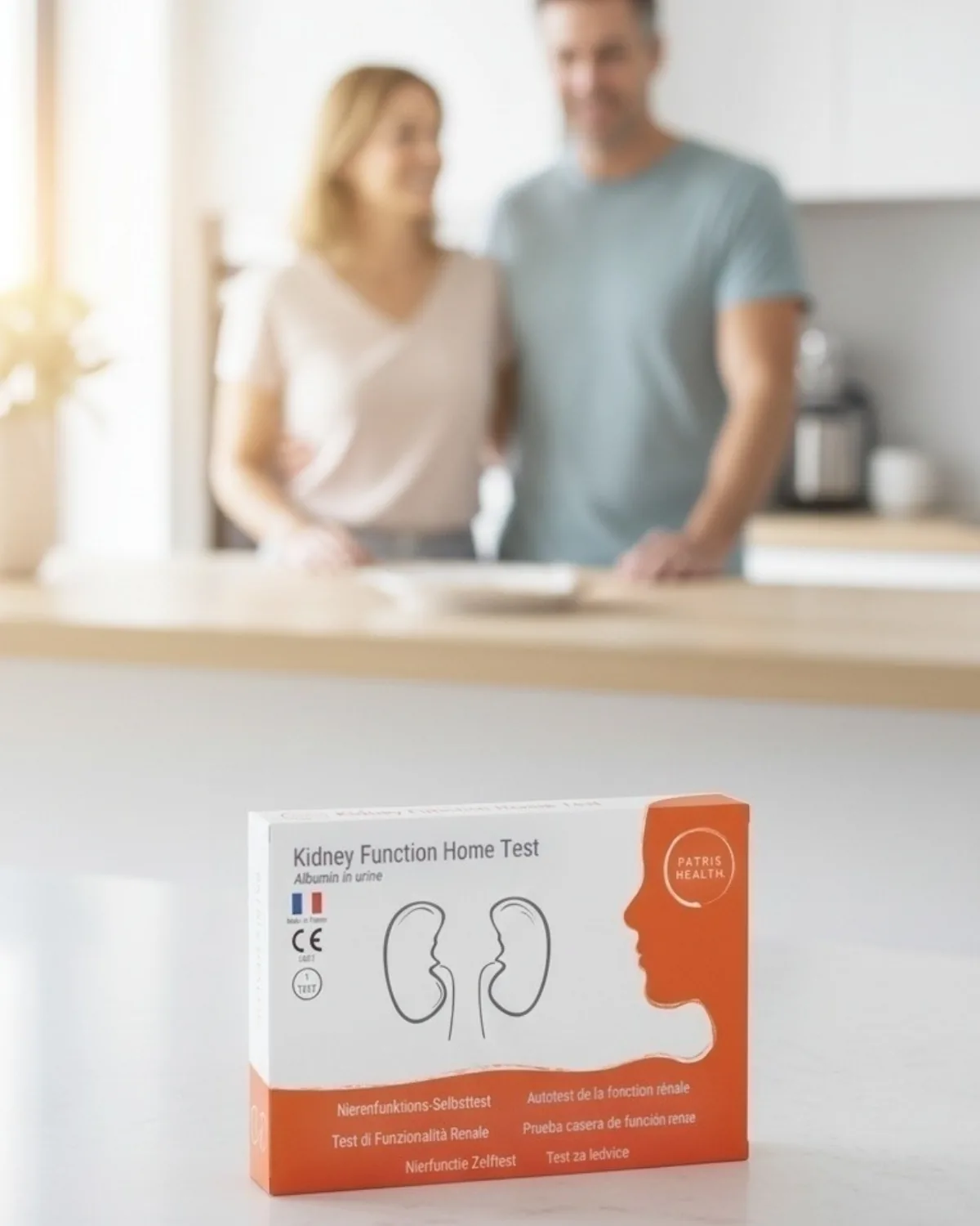 Boîte de l’Autotest de la fonction rénale Patris Health sur un plan de travail de cuisine, un couple à l’arrière-plan