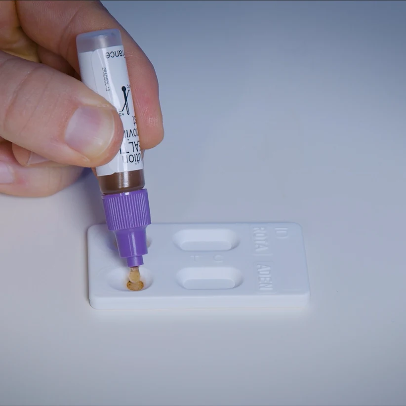 Autotest de rotavirus et adénovirus Patris Health – étape 3, ajout des gouttes d’échantillon extrait dans l’un des deux puits échantillon